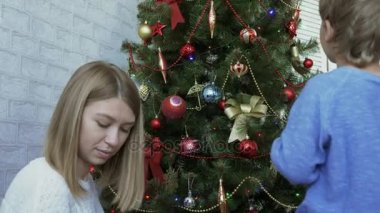 Anne ve çocuk Noel ağacı birlikte gündüz süslemeleri.