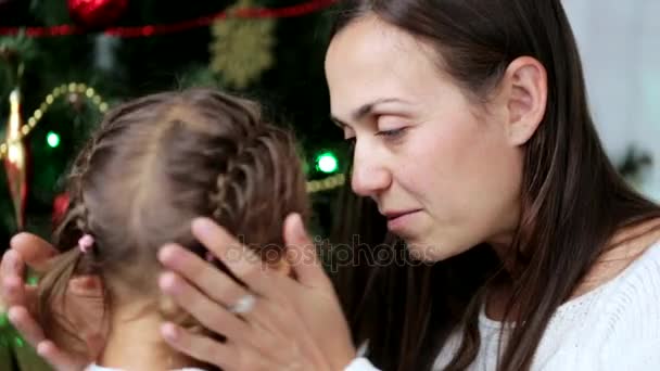 クリスマス ツリーの横にクリスマスの時間の彼女の子供との楽しみを持つ幸せな母 — ストック動画