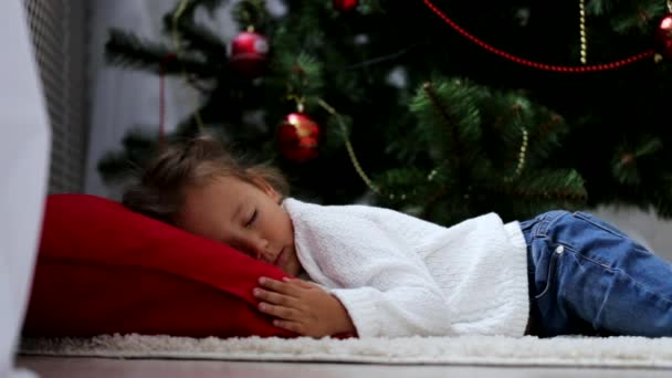 Madre viene y cubre duerme en el suelo bebé con un cuadros rojos en la víspera de Navidad . — Vídeos de Stock