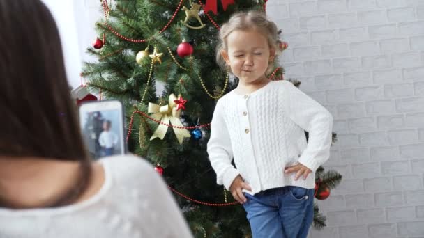 Alegre niña bailando y jugando al mono cerca del árbol de Navidad — Vídeos de Stock