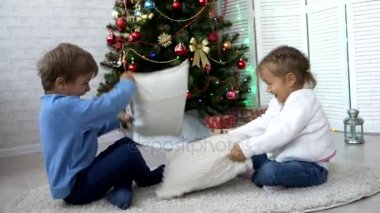 Oynak kardeşler Noel ağacının yanındaki evde yastık ile mücadele.