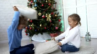 Oynak kardeşler Noel ağacının yanındaki evde yastık ile mücadele.