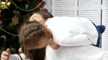 Mutlu anne Noel ağacının yanındaki çocuk kızı ile eğleniyor