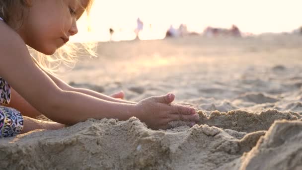 Lilla söta flicka byggnad sand slott på stranden. — Stockvideo