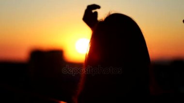 Genç kadın saç balkonda günbatımında dokunmadan arka görmek