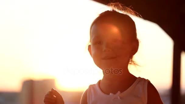 Liten flicka dansa i solnedgången på balkongen. Silhouette närbild skott. — Stockvideo