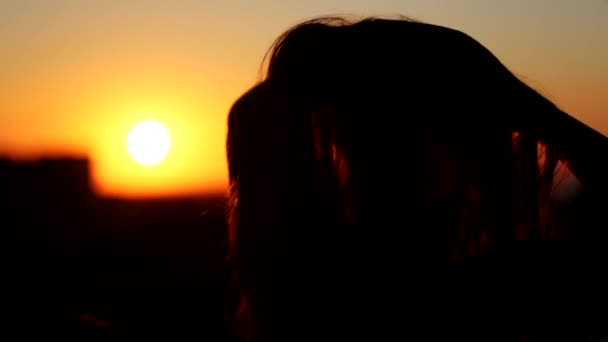 Vista da vicino posteriore della giovane donna che tocca i capelli sul balcone al tramonto — Video Stock