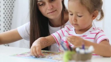 Anne ve kızı ışık oturma odasında birlikte bir bulmaca