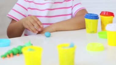 Genç çekici anne küçük şirin kızı ile oynamak kil modelleme ile