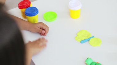 Genç çekici anne küçük şirin kızı ile oynamak kil modelleme ile