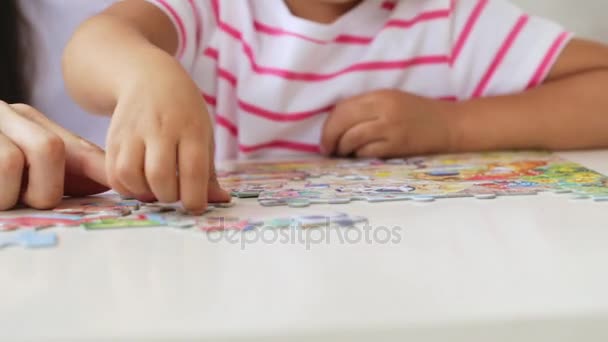 Matka i córka robi puzzle razem w jasny pokój dzienny — Wideo stockowe