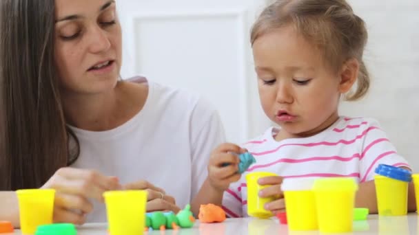 Jovem mãe atraente com pouco bonito filha jogar com argila modelagem — Vídeo de Stock