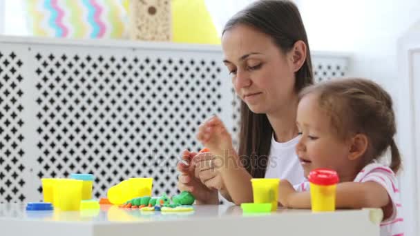 Jeune mère attrayante avec petite fille mignonne jouer avec l'argile de modélisation — Video