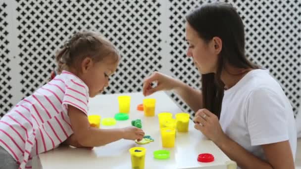 Jeune mère attrayante avec petite fille mignonne jouer avec l'argile de modélisation — Video