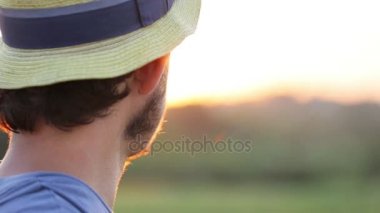Gün batımında şapkalı genç çiftçi portresi
