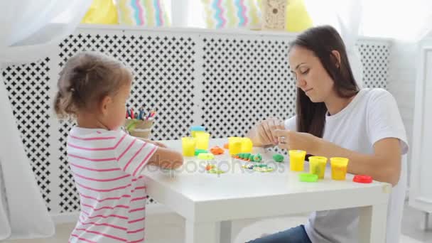 Moeder met schattig dochtertje spelen met klei op lichte woonkamer modelleren. — Stockvideo