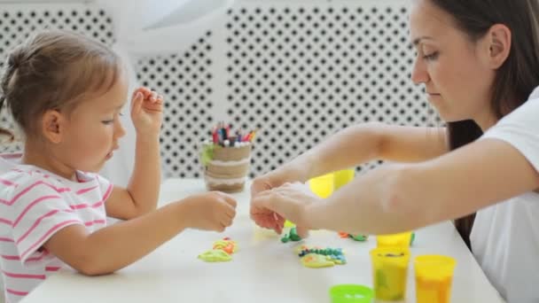 Moeder met schattig dochtertje spelen met klei op lichte woonkamer modelleren. — Stockvideo