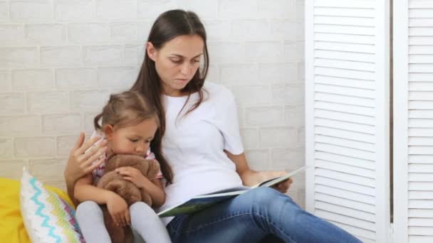 Mladá matka čítanka pro svou malou dceru. — Stock video