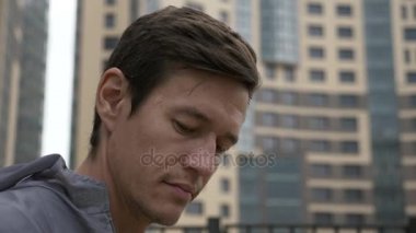 Mühendis üniformalı arka planda bina ile gözlük kaldırır.