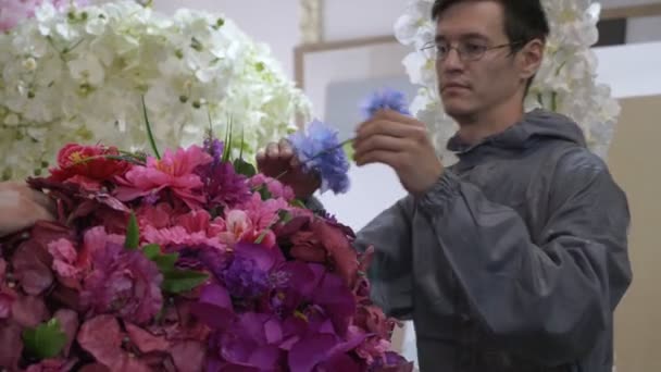 Работники в форме выполняют композицию цветов в производственном цехе — стоковое видео