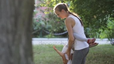 Eğleniyor ve parkta oynarken küçük kızıyla birlikte genç anne