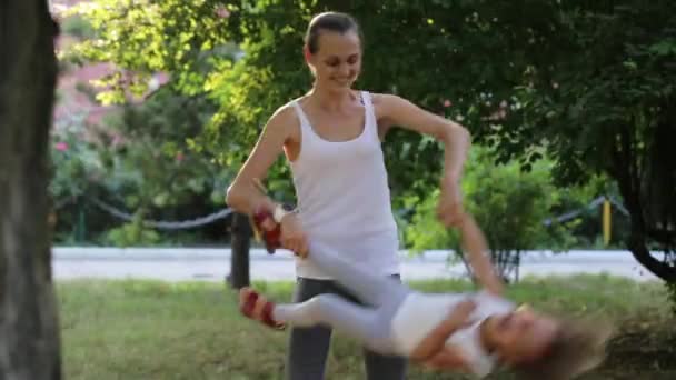 Giovane madre con la sua piccola figlia divertirsi e giocare nel parco — Video Stock