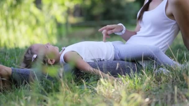 Feliz familia madre y bebé divirtiéndose al aire libre, jugando juntos en el parque verde — Vídeo de stock