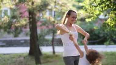 Eğleniyor ve parkta oynarken küçük kızıyla birlikte genç anne