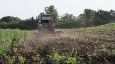 Kara toprağı pulluk otlar ile büyümüş sabah tarlayı traktör