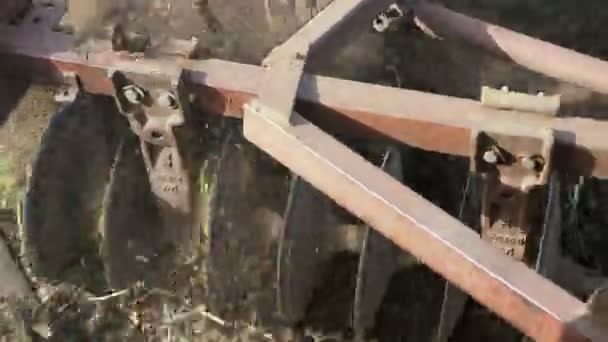 Closeup of plow attached to a tractor plowing a field. — Stock Video