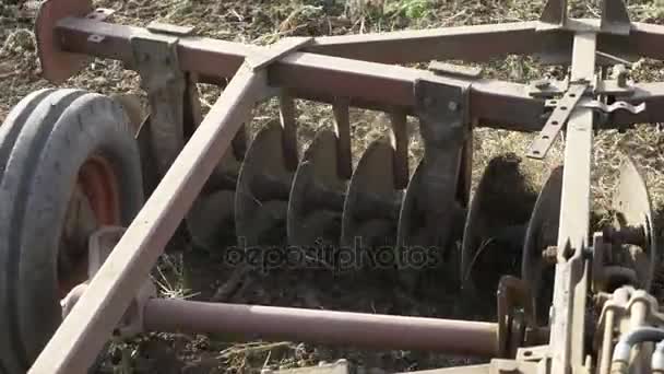 Närbild av plogen bifogas en traktor plöjer ett fält. — Stockvideo