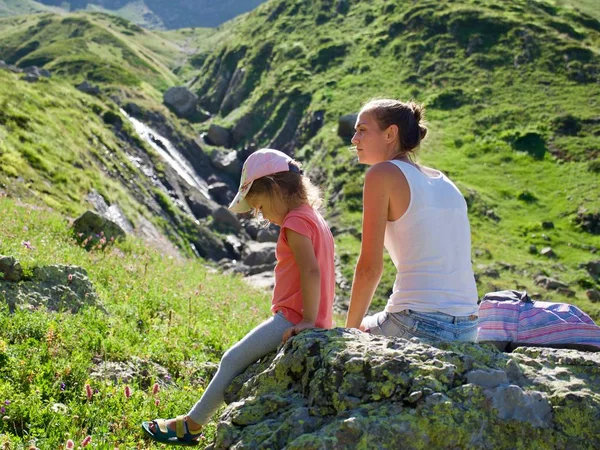 Mutter und Tochter ruhen sich bei Ausflug auf dem großen Stein aus. — Stockfoto