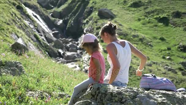 母亲和女儿在那块大石头上休息旅行游览. — 图库视频影像