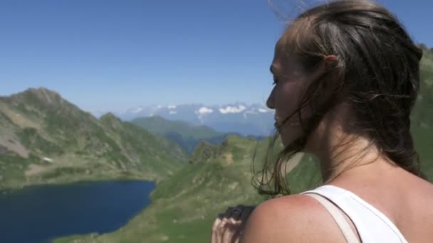 Молодая туристка наслаждается прекрасным видом на озеро в горах — стоковое видео