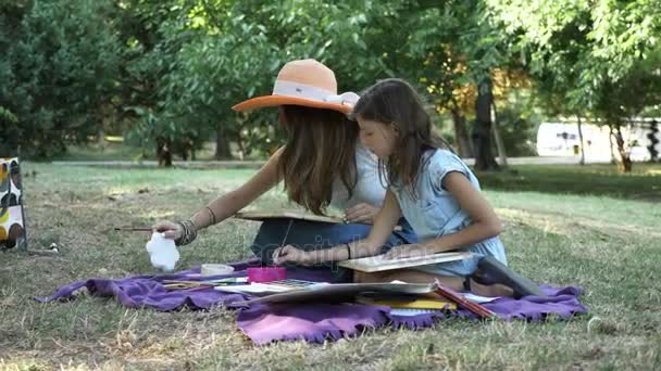 Frau mit Tochter zeichnet mit Aquarellfarben im Park — Stockvideo
