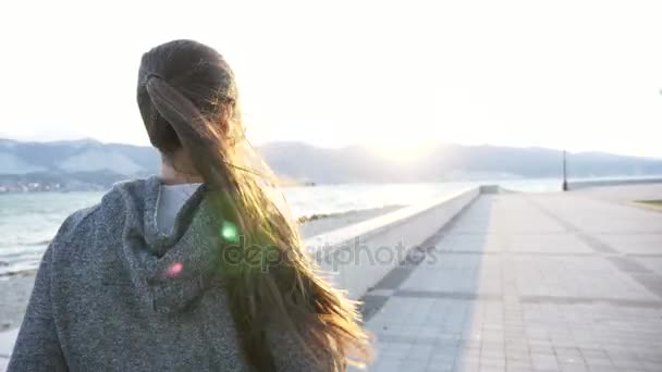 Jovem mulher vestida com capuz correndo na cidade à beira-mar — Vídeo de Stock