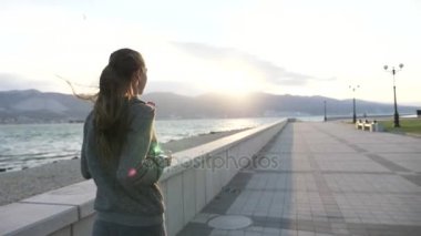 Seafront adlı şehirde koşu kapüşonlu genç kadın giyinmiş