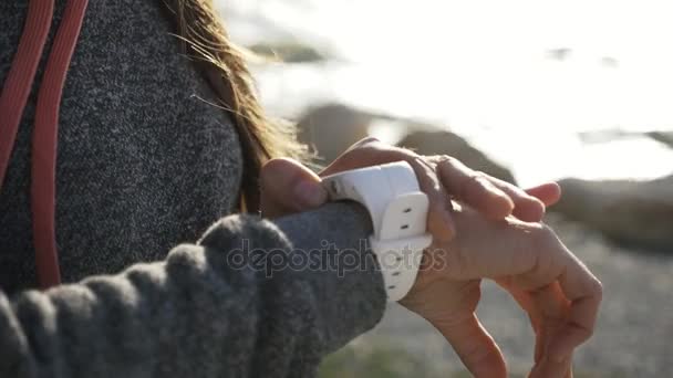 Closeup žena pomocí smart sport Běh hodinky na pláži — Stock video