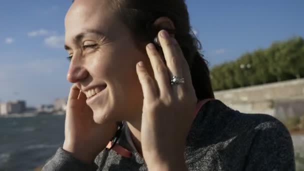 Mladá žena veselá zábavná poslech hudby do sluchátek, úsměv, smích a tanec — Stock video