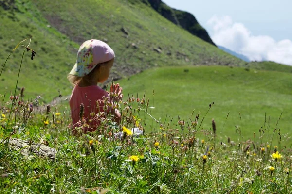 Pequena menina bonito meditando na paisagem da montanha . — Fotografia de Stock
