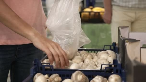 Женщина выбирает свежие грибы в продуктовом отделе . — стоковое видео