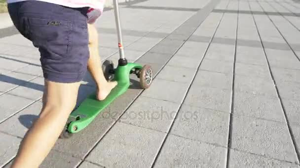 Mutlu sevimli küçük kız sürme tekme scooter güneşli yaz günü Park — Stok video