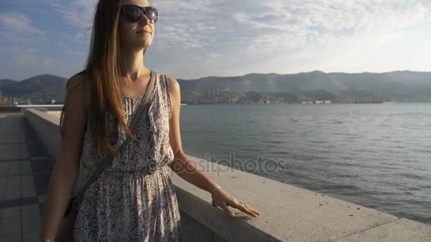 Porträt einer jungen, attraktiven Frau, die an der Strandpromenade der Stadt spaziert, Steadicam-Aufnahme — Stockvideo