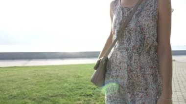 Elbiseli genç kadın el çantası akıllı telefondan çıkarır ve görüşmeler başlıyor