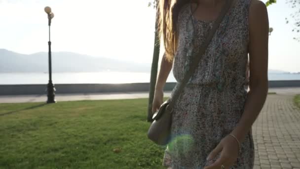 Junge Frau im Kleid zückt ihr Smartphone aus der Handtasche und beginnt Gespräche — Stockvideo