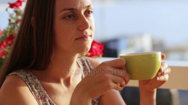 Genç güzel kadın güzel defne deniz manzaralarını eserini bir kafede oturuyor.