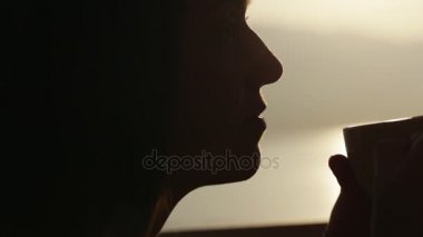 Yakın çekim siluet yüz genç kadınların bir kafe ve çay içme oturur