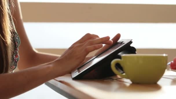 Gros plan mains féminines en utilisant une tablette dans un café en plein air . — Video