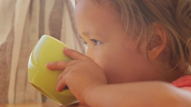 Linda niña beber bebida de la taza en el balcón — Vídeo de stock