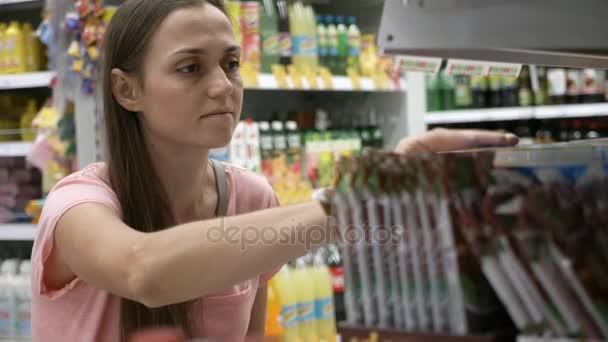 Retrato de la mujer eligiendo mercancías en el departamento de comestibles del centro comercial — Vídeos de Stock